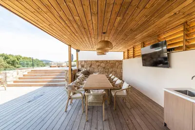 a wooden deck with a wooden table and chairs at Villa Monte Sereno Pinarellu in Pinarellu