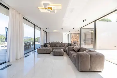 a large living room with couches and large windows at Villa Monte Sereno Pinarellu in Pinarellu