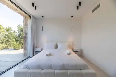 a bedroom with a bed and a large window at Villa Monte Sereno Pinarellu in Pinarellu
