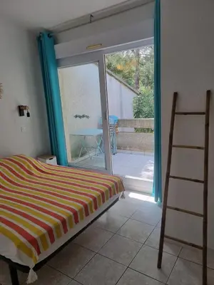 a bedroom with a bed and a sliding glass door at Saint Cyprien, Corse du Sud - Mini Villa - 6 couchages in Lecci