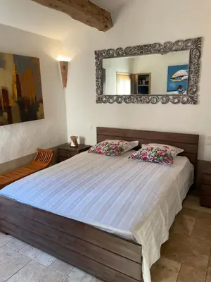 a bedroom with a large bed with a mirror on the wall at Casa di Sognu in Porto-Vecchio