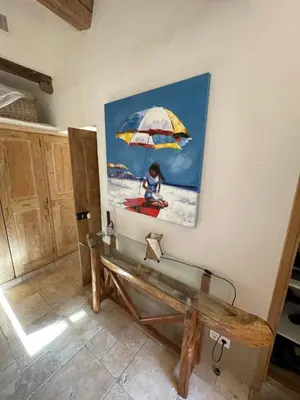 a painting of a woman on the beach with an umbrella at Casa di Sognu in Porto-Vecchio