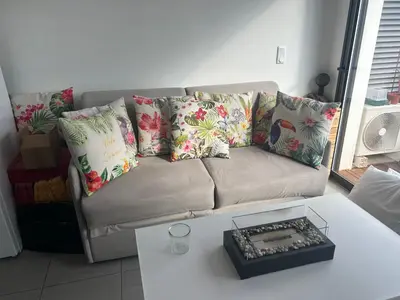 a couch with pillows and a table in a living room at Porticcio in Grosseto-Prugna