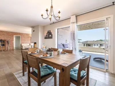 a dining room with a table and chairs and a large window at Apartment La vallée by Interhome in Aléria