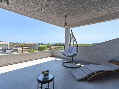 a cat sitting on a balcony with a swing at Apartment La vallée by Interhome in Aléria