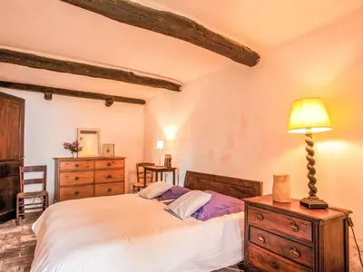 a bedroom with a bed and a lamp on a dresser at Holiday Home Formicaccia by Interhome in Cervione