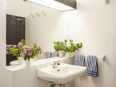 a bathroom with a sink and a mirror and flowers at Holiday Home Formicaccia by Interhome in Cervione
