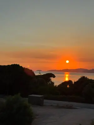 a sunset over the water with the sun in the sky at La Petite Civita de Piétrosella in Pietrosella
