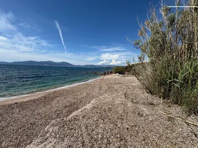 a beach with a rocky shore and the ocean at La Petite Civita de Piétrosella in Pietrosella