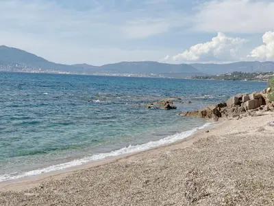 a beach with a rocky shore and the ocean at La Petite Civita de Piétrosella in Pietrosella