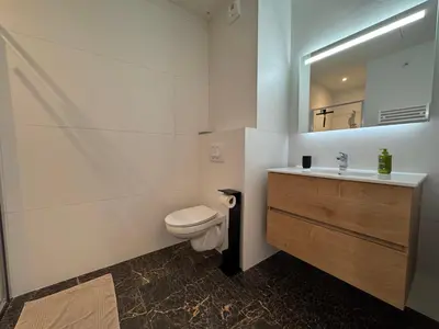 a bathroom with a toilet and a sink and a mirror at La Petite Civita de Piétrosella in Pietrosella