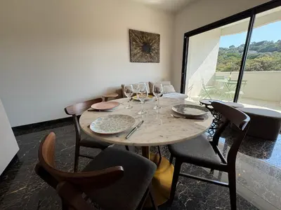 a dining room with a table with wine glasses at La Petite Civita de Piétrosella in Pietrosella