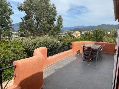 a patio with a table and chairs on a balcony at Porticcio, Villa Terra di Sole in Grosseto-Prugna
