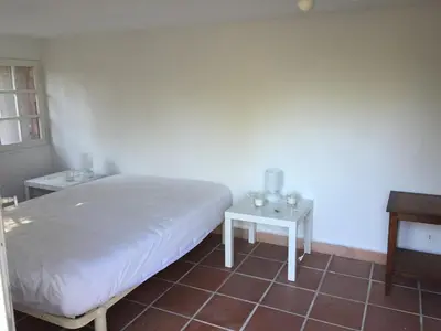 a bedroom with a white bed and two tables at Porticcio, Villa Terra di Sole in Grosseto-Prugna