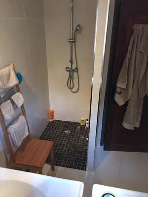 a bathroom with a shower with a chair and a sink at Porticcio, Villa Terra di Sole in Grosseto-Prugna