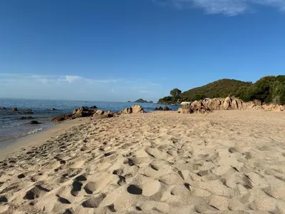 a sandy beach with rocks in the water at Cocon chaleureux bord de plage vue sanguinaire in Ajaccio
