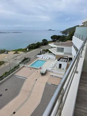 a view from the balcony of a house with a swimming pool at Cocon chaleureux bord de plage vue sanguinaire in Ajaccio
