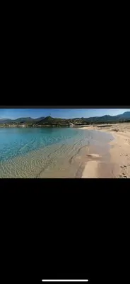 a picture of a beach with water and mountains at Studio Corse bord de mer in Calcatoggio