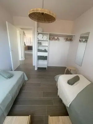 a room with two beds and a closet with shelves at U Mandriolu in Prunelli-di-Fiumorbo