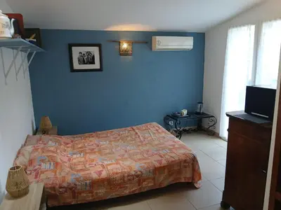 a bedroom with a bed and a blue wall at Chambre avec SDB WC à 100 m du départ du GR20 in Calenzana