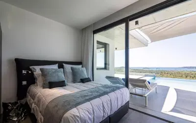 a bedroom with a bed and a large window at Villa Bianca in Zonza