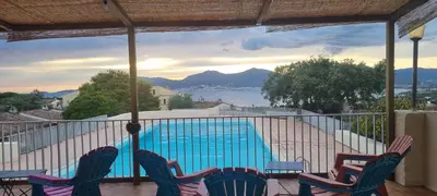 a balcony with chairs and a swimming pool at Maison porticcio vue mer chez Olivier in Grosseto-Prugna