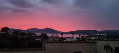 a sunset over a city and a body of water at Maison porticcio vue mer chez Olivier in Grosseto-Prugna