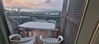 a white table and chairs on a balcony with a view at Maison porticcio vue mer chez Olivier in Grosseto-Prugna