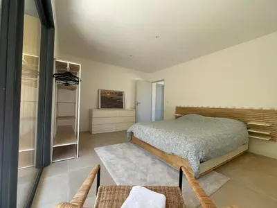 a bedroom with a bed and a tv on the wall at T2 Cosy dans le village de Piana in Piana