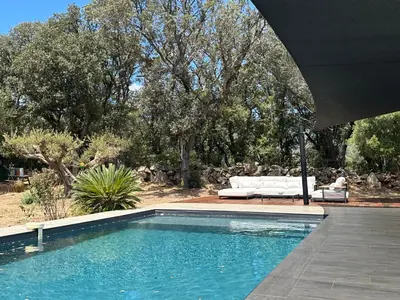 a swimming pool with a white couch and a table and chairs at Villa Casa Pietranera in Porto-Vecchio