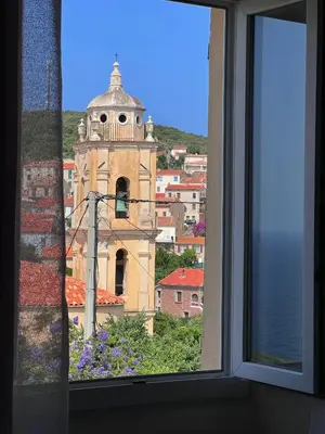 a view of a church from a window at 55m2 de charme - Vue exceptionnelle églises & mer in Cargèse