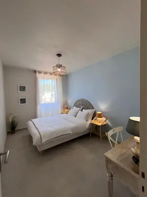 a bedroom with a bed and a table and a window at 55m2 de charme - Vue exceptionnelle églises & mer in Cargèse
