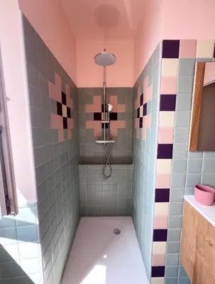 a bathroom with a tub and a shower with colorful tiles at 55m2 de charme - Vue exceptionnelle églises & mer in Cargèse