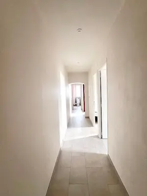 an empty hallway with white walls and a tile floor at 55m2 de charme - Vue exceptionnelle églises & mer in Cargèse