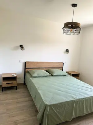 a bedroom with a bed with a green comforter at Logement indépendant avec piscine privée in Penta-di-Casinca