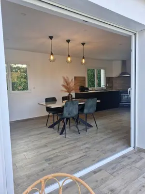 a dining room and kitchen with a table and chairs at Logement indépendant avec piscine privée in Penta-di-Casinca