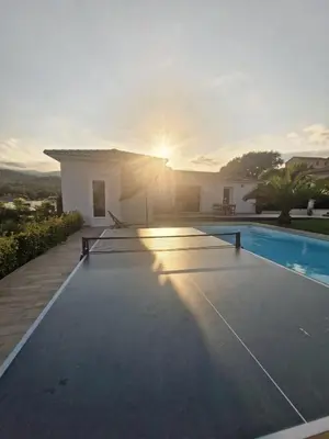 a villa with a swimming pool with the sun setting at Logement indépendant avec piscine privée in Penta-di-Casinca