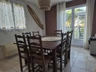 a dining room with a wooden table and chairs at U PINU Appartement 3 chambres in Olmeto