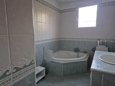 a bathroom with a bath tub and a sink at U PINU Appartement 3 chambres in Olmeto