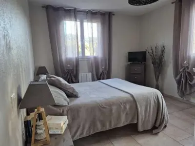 a bedroom with a large bed and a window at U PINU Appartement 3 chambres in Olmeto