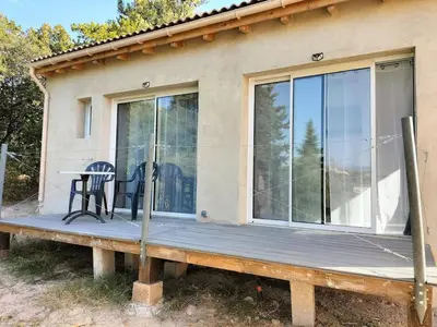 a house with a deck with a table on it at Studio avec mezzanine in Cuttoli-Corticchiato