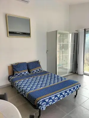 a large bed in a room with a mirror at Studio avec mezzanine in Cuttoli-Corticchiato