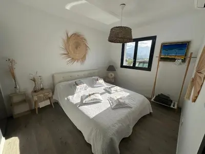 a bedroom with a bed with towels on it at Proche Porticcio superbe T3 confort moderne au calme belle vue maquis et montagne in Eccica-Suarella