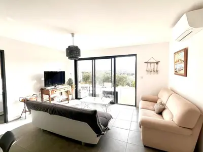a living room with a couch and a tv at Proche Porticcio superbe T3 confort moderne au calme belle vue maquis et montagne in Eccica-Suarella