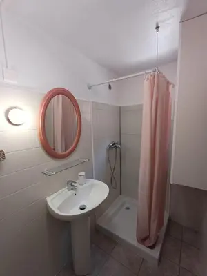 a bathroom with a sink and a shower with a mirror at Appartement en duplex au cœur de Piana in Piana