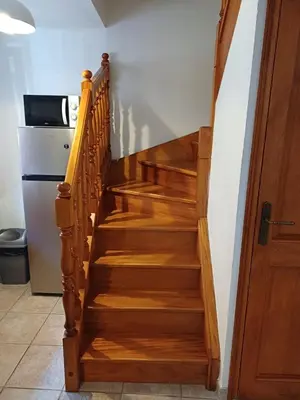 a wooden staircase in a kitchen with a refrigerator at Appartement en duplex au cœur de Piana in Piana