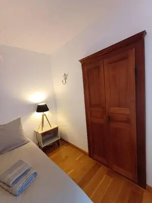 a bedroom with a bed and a wooden cabinet at Appartement en duplex au cœur de Piana in Piana