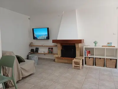 a living room with a fireplace and a tv on the wall at Appartement en duplex au cœur de Piana in Piana