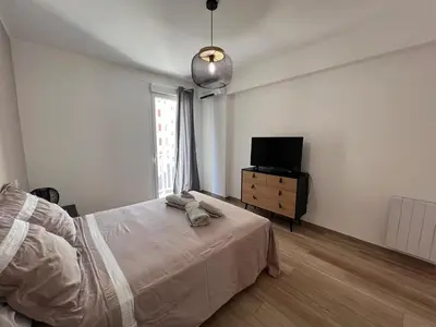 a bedroom with a bed and a flat screen tv at Appartement Résidence in Ajaccio