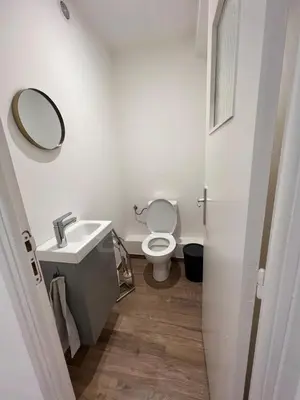 a bathroom with a toilet and a sink and a mirror at Appartement Résidence in Ajaccio